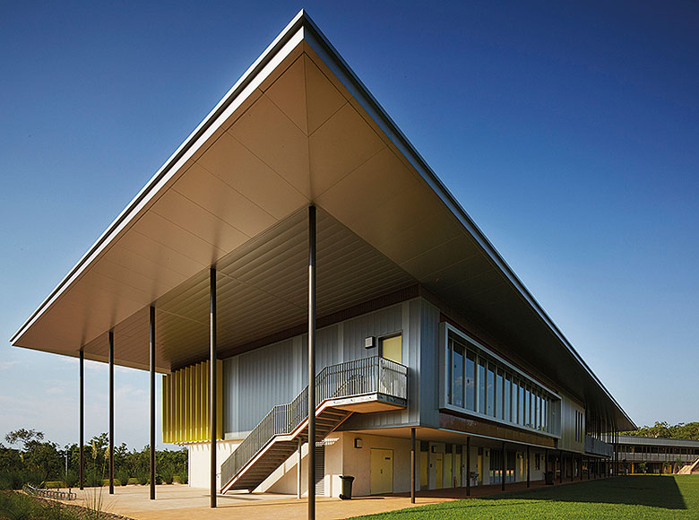 Cantilevered roofs sitting lantern-like atop the weightiness of a concrete block work-base, MacKillop Catholic College in the Northern Territory, roofing, wall cladding, soffits and flashing made from COLORBOND® steel in the colours Windspray®, Jasper®, and Shale Grey™